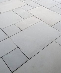 Patio pack of grey sawn sandstone paving laid in garden